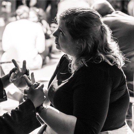 Melaine Brown assisting a deaf blind person at an event